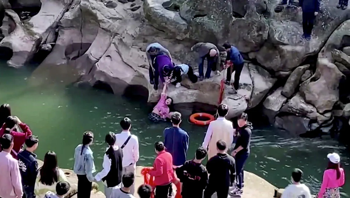 In this screengrab taken from video, Stephen Ellison, British consul-general in Chongqing, rescues a drowning student at a scenic spot in Chongqing, China, on Nov. 14, 2020. (Jiang Lang via British consulate in Chongqing/via Reuters TV)