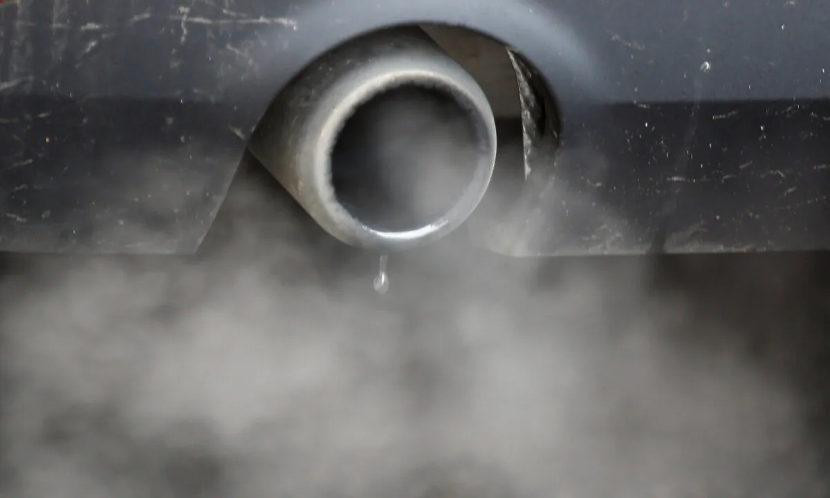 An exhaust emits fumes as a car is driven through Richmond in London on Dec. 2, 2016. (Peter Nicholls//Reuters)