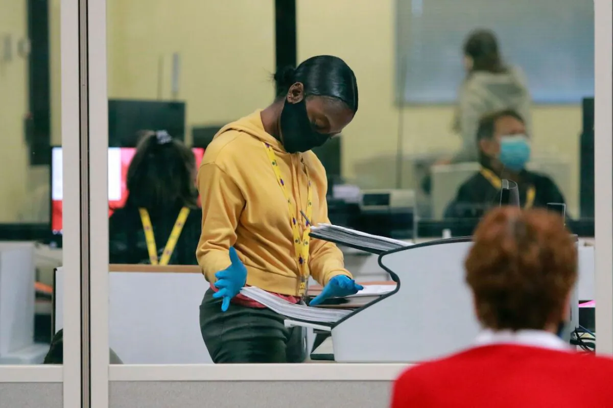 A worker handles official ballots at Clark County Election Department in a glassed-off in North Las Vegas, Nevada, on Nov. 5, 2020. (Ronda Churchill/AFP)