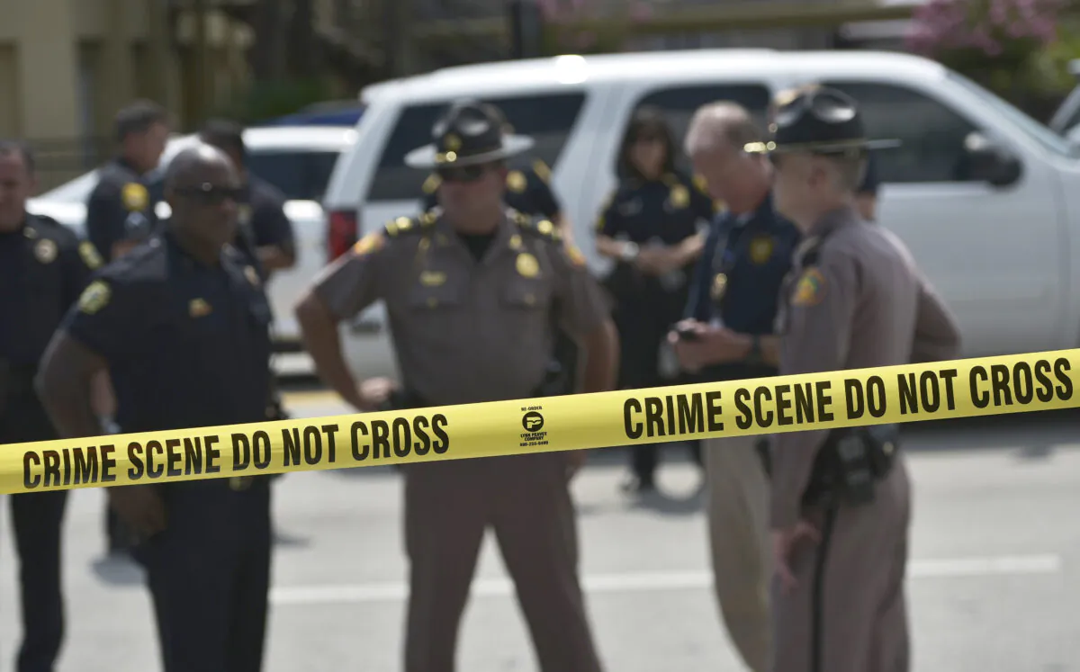 Police stand behind a crime scene tape in a file photo. (Mandel Ngan/AFP via Getty Images)