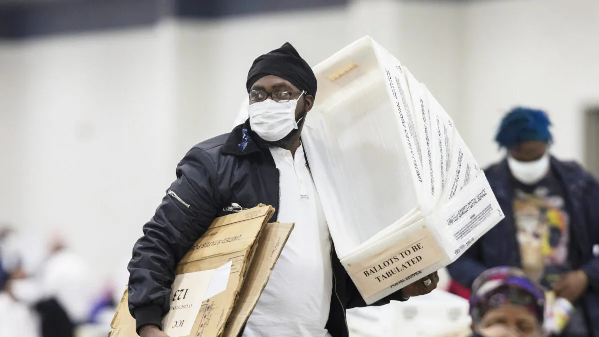A worker with the Detroit Department of Elections carries empty boxes used to organize absentee ballots after nearing the end of the absentee ballot count at the Central Counting Board in the TCF Center in Detroit, Mich., on Nov. 4, 2020. (Elaine Cromie/Getty Images)