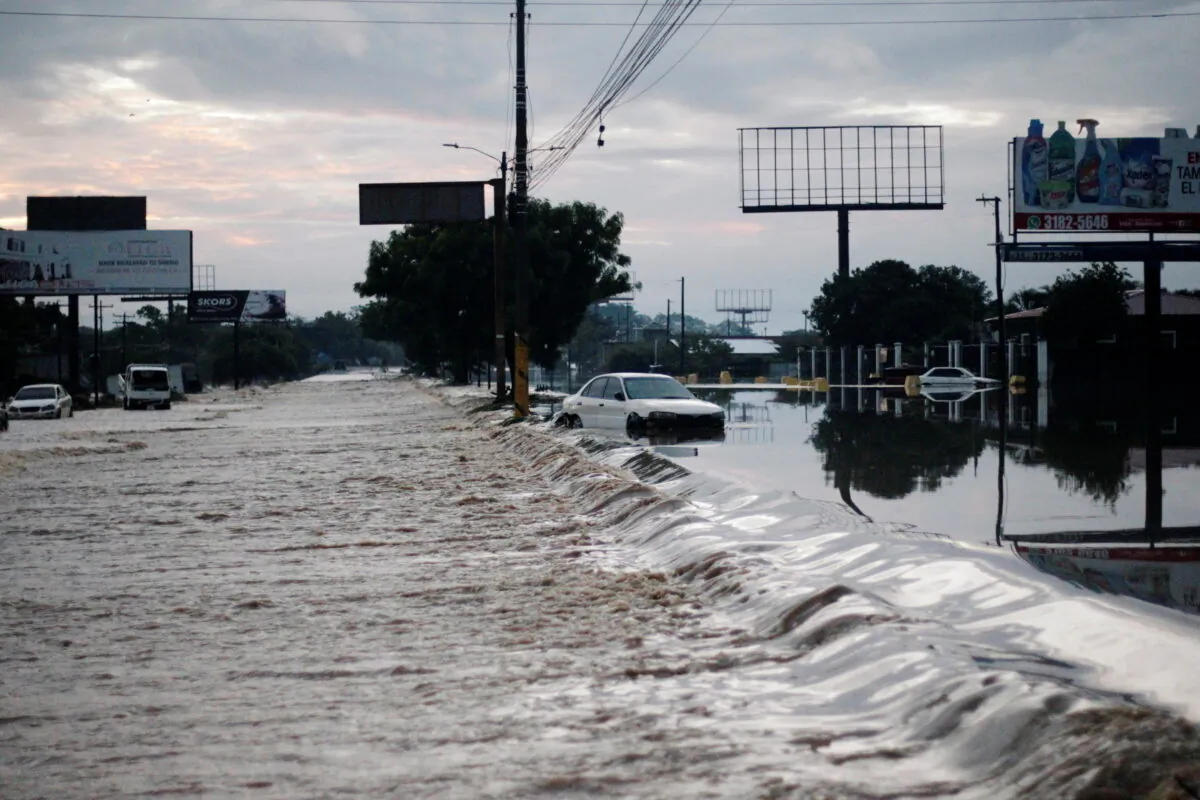 A stranded car is seen at a road flooded by the Chamelecon River due to heavy rain caused by Storm Iota, in La Lima, Honduras, on Nov. 19, 2020. (Jorge Cabrera/Reuters)