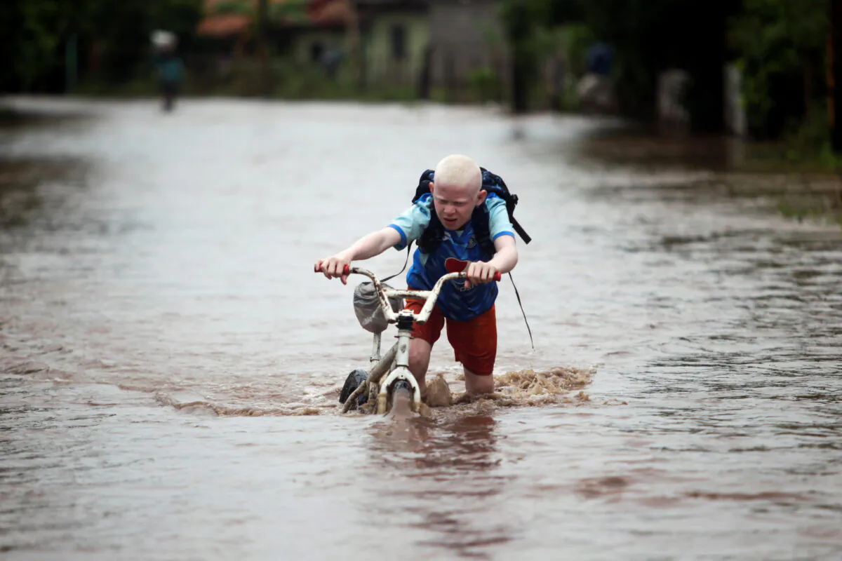 A child pushes his bicycle through a flooded road after the passing of Storm Iota, in Marcovia, Honduras, on Nov. 18, 2020. (Jorge Cabrera/Reuters)