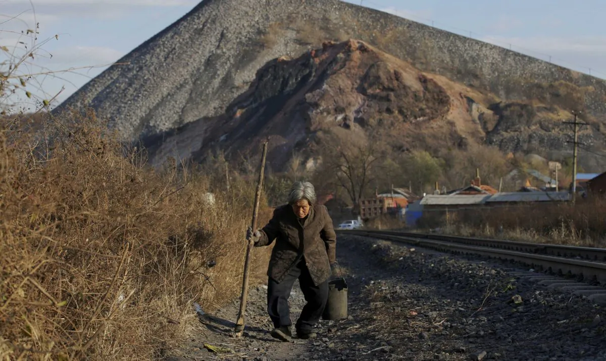 An elderly villager walks along a railway line on the outskirts of Jixi, in Heilongjiang province, China, on Oct. 24, 2015. (Jason Lee/Reuters)