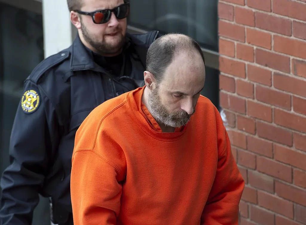 Matthew Raymond is escorted at Court of Queen's Bench in Fredericton, on Dec. 18, 2019. (The Canadian Press/Andrew Vaughan)
