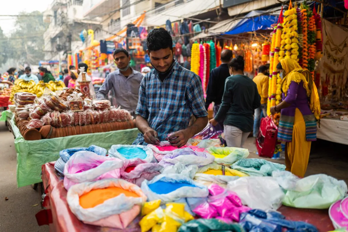 A vendor packs color powder used to make decorations for Diwali, the Hindu Festival of Lights, as he waits for customers in a market area in New Delhi on Nov. 14, 2020. (Jewel Samad/AFP via Getty Images)
