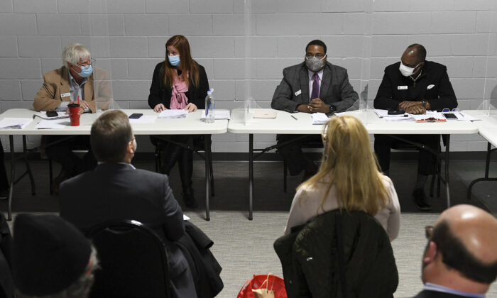 Wayne County Board of Canvassers, from left, Republican member William Hartmann, Republican chairperson Monica Palmer, Democrat vice chair Jonathan Kinloch, and Democratic member Allen Wilson discuss a motion to certify election results during a board meeting in Detroit, Mich., on Nov. 17, 2020. (Robin Buckson/Detroit News via AP)