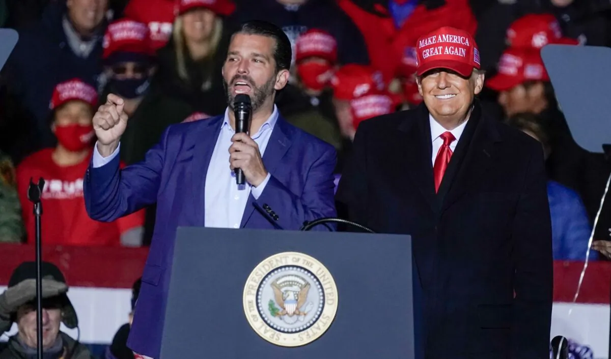 Then-President Donald Trump watches as Donald Trump Jr. speaks at a campaign event at the Kenosha Regional Airport in Kenosha, Wis., on Nov. 2, 2020. (Morry Gash/File/AP)