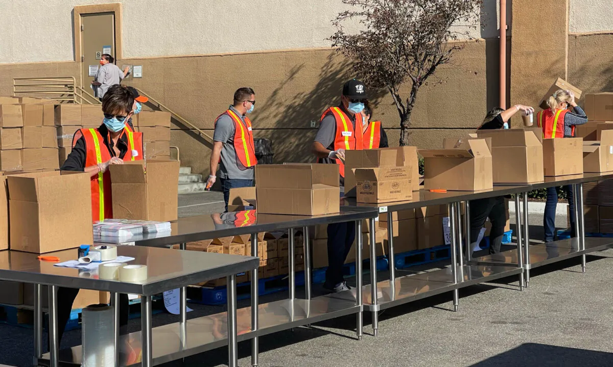 Volunteers prepare Thankgiving meal boxes for the needy at Second Harvest Food Bank headquarters in Irvine, Calif., on Nov. 19, 2020. (Drew Van Voorhis/The Epoch Times)