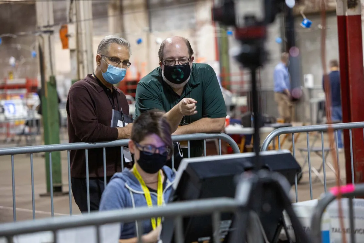 Observers watch a poll worker tabulate ballots at the Allegheny County Election Warehouse after the election in Pittsburgh, Pennsylvania, U.S. Nov. 6, 2020. (Reuters/John Altdorfer)