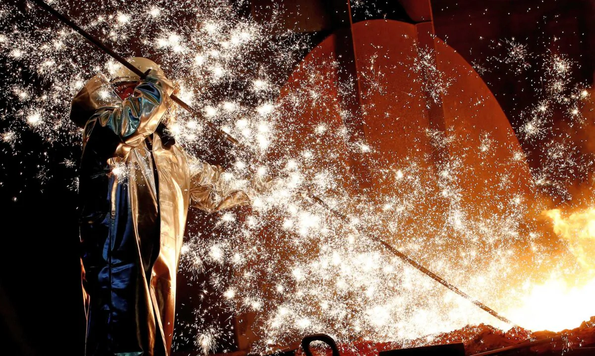 In this file photo a steel worker of Germany’s industrial conglomerate ThyssenKrupp AG stands a mid of emitting sparks of raw iron from a blast furnace at Germany’s largest steel factory in Duisburg, Germany on Jan. 28, 2019. (Wolfgang Rattay/Reuters)