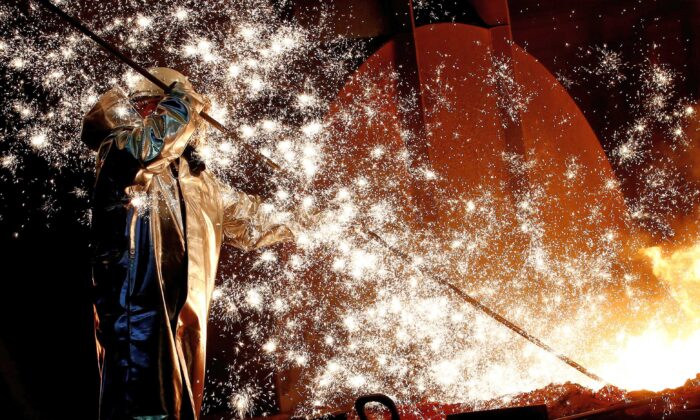 A steel worker of Germany’s industrial conglomerate ThyssenKrupp AG stands a mid of emitting sparks of raw iron from a blast furnace at Germany’s largest steel factory in Duisburg, Germany on Jan. 28, 2019. (Wolfgang Rattay/Reuters)