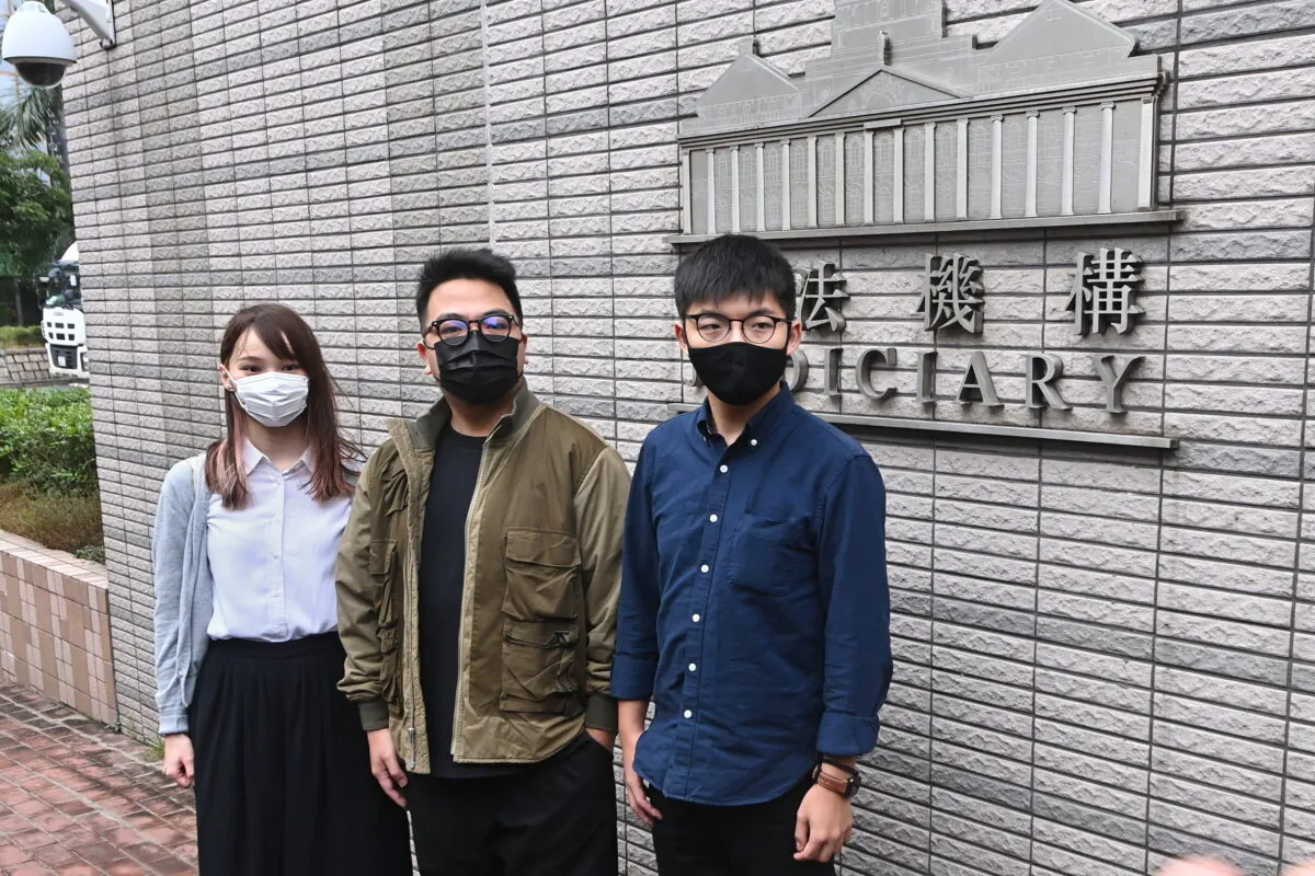 (L-R) Agnes Chow, Ivan Lam, and Joshua Wong pose for pictures before their court session in Hong Kong on Nov. 23, 2020. (Song Bilung/The Epoch Times)