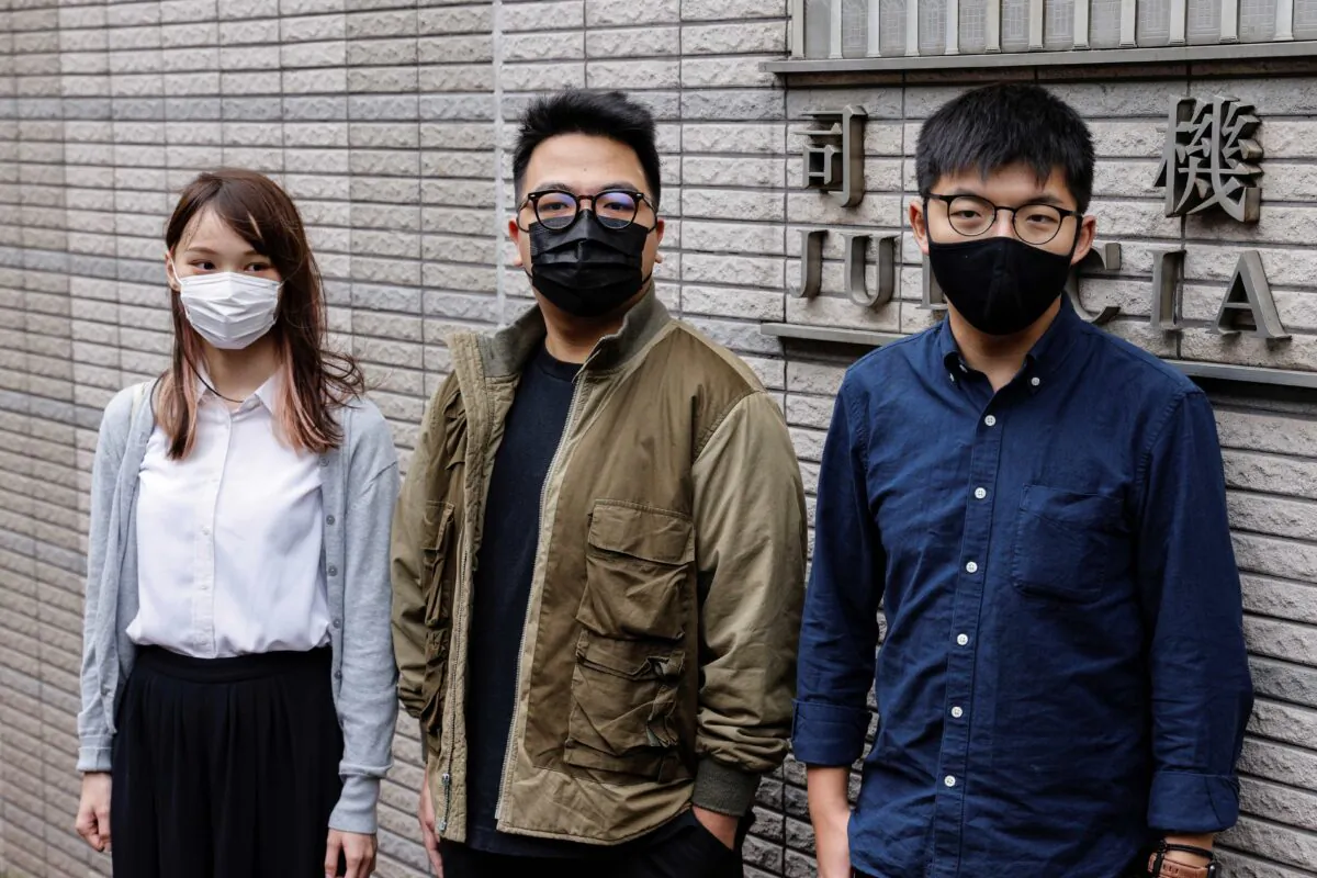 Pro-democracy activists Ivan Lam, Joshua Wong, and Agnes Chow arrive at the West Kowloon Magistrates' Courts to face charges related to illegal assembly stemming from 2019, in Hong Kong on Nov. 23, 2020. (Tyrone Siu/Reuters)