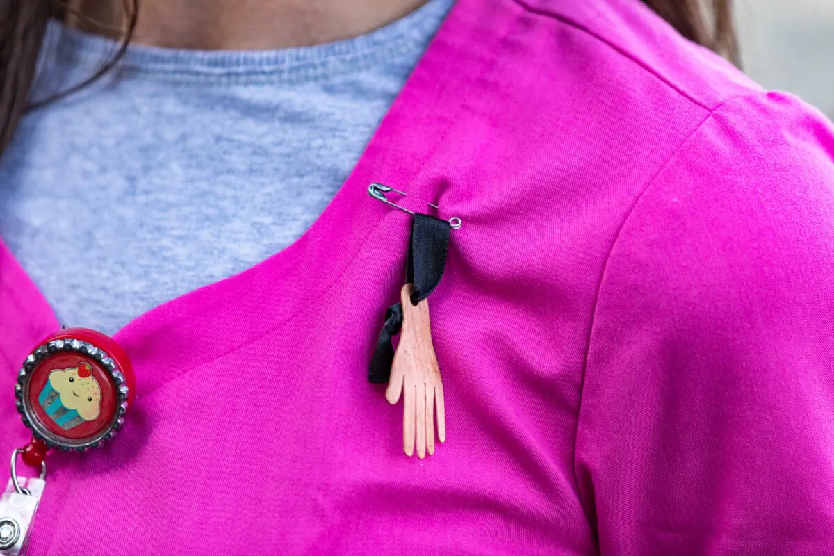 A medal made by Long Beach College students is pinned to the uniform of a healthcare worker at Lakewood Regional Medical Center in Lakewood, Calif., on Nov. 20, 2020. (John Fredricks/The Epoch Times)