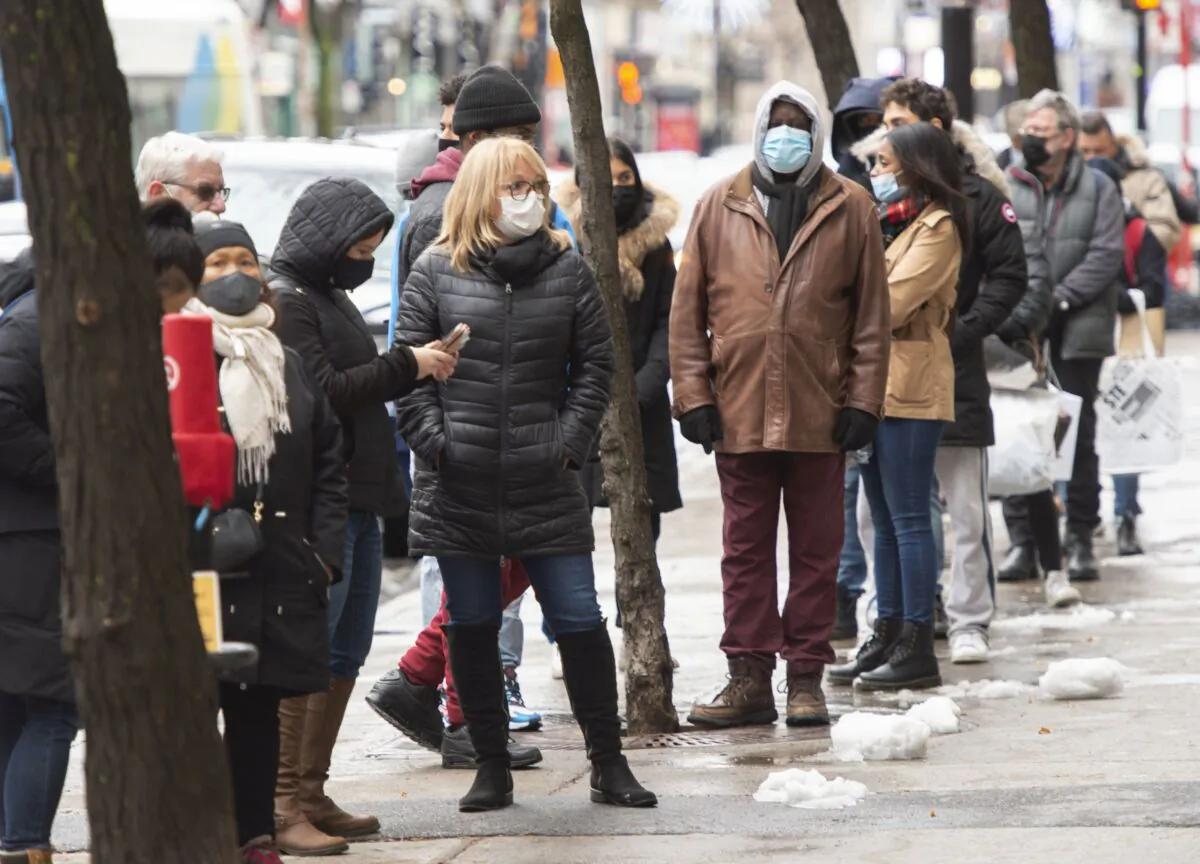 People line up outside a store in Montreal on Nov. 23, 2020, as various levels of COVID-19 restrictions continue across the country. (The Canadian Press/Ryan Remiorz)