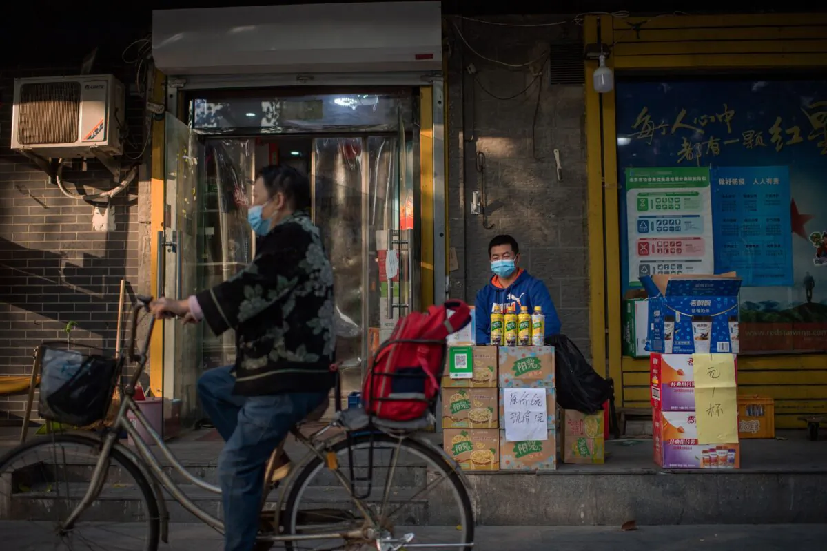 A vendor sells beverages outside a shop on a street in Beijing, China on Oct. 19, 2020. (NICOLAS ASFOURI/AFP via Getty Images)
