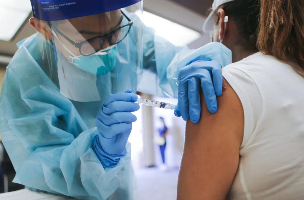 A nurse administers a flu vaccination shot to a woman at a free clinic held at a local library in Lakewood, Calif., on Oct. 14, 2020. (Mario Tama/Getty Images)