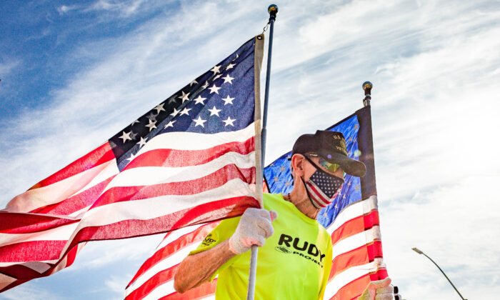 罗伯特·科勒 (Robert Kohler) 于 2020 年 11 月 21 日在加利福尼亚州达纳角举行了虚拟的 2020 土耳其小跑，手持两面巨大的美国国旗。（John Fredricks/媒体时报）