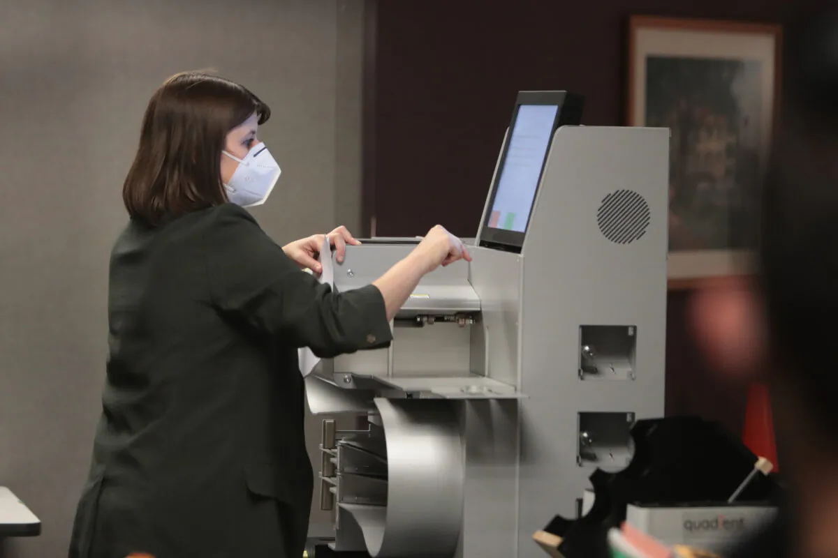 Claire Woodall-Vogg, executive director of the Milwaukee election commission, collects the count from absentee ballots from a voting machine in Milwaukee, Wis., on Nov. 20, 2020. (Scott Olson/Getty Images)