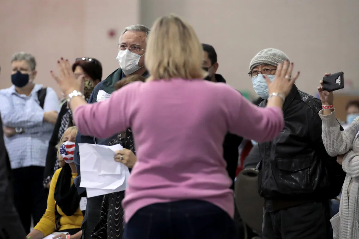 An election official calms unruly observers as procedural issues are argued during the process of recounting ballots, at the Wisconsin Center in Milwaukee, Wis., on Nov. 20, 2020. (Scott Olson/Getty Images)