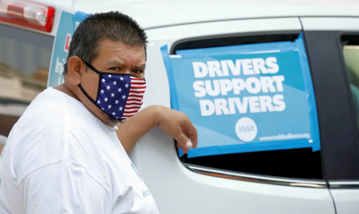 Rideshare driver Jesus Jacobo Zepeda of Lancaster, California takes part in a rally as part of a statewide day of action to demand that ride-hailing companies Uber and Lyft follow California law and grant drivers “basic employee rights,” in Los Angeles, Calif., on Aug. 20, 2020. (Mike Blake/Reuters)