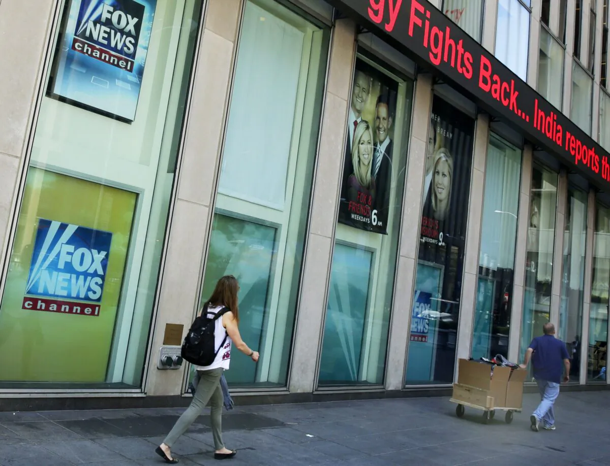 People pass the News Corporation headquarters building and Fox News studios in New York on Aug. 1, 2017. (Richard Drew/AP Photo)