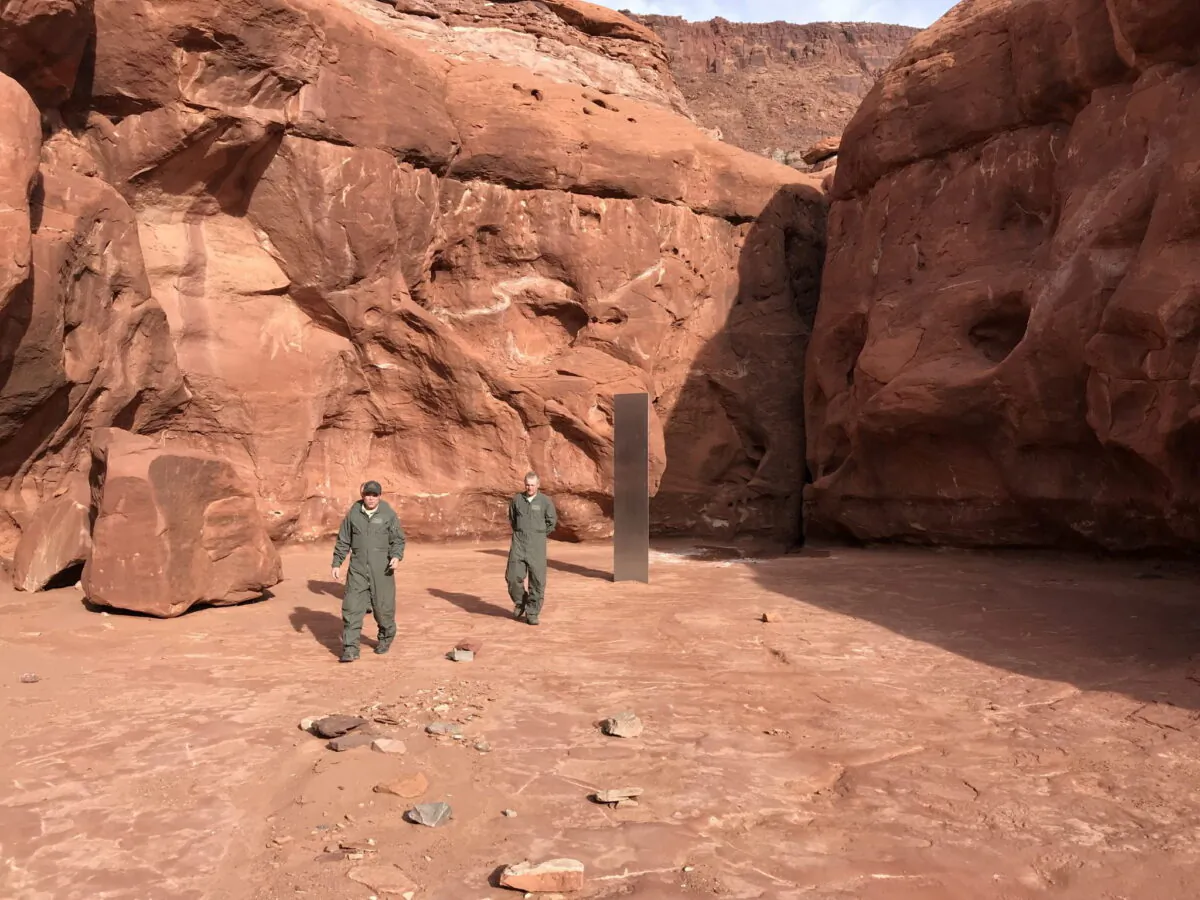 Utah Department of Public Safety Aero Bureau and Utah Division of Wildlife Resources crew members walk near a metal monolith they discovered in a remote area of Red Rock Country in Utah, U.S. on Nov. 18, 2020. (Utah Department of Public Safety via REUTERS)