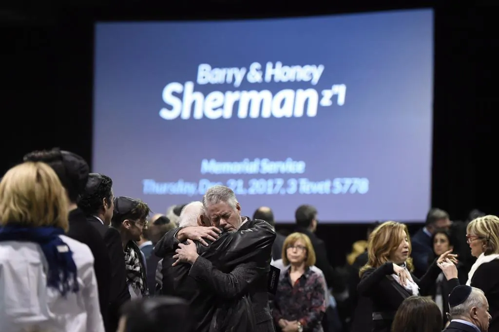 People embrace before the start a memorial service for Apotex billionaire couple Barry and Honey Sherman in Mississauga, Ontario on Dec. 21, 2017. (The Canadian Press/Nathan Denette)