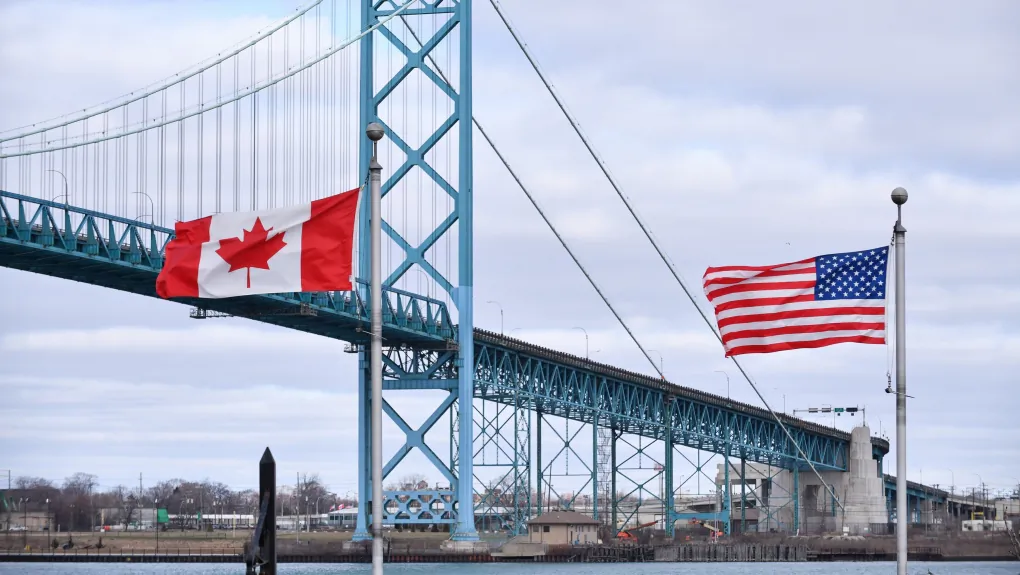 Canadian and American flags fly near the Ambassador Bridge at the Canada-USA border crossing in Windsor, Ont. on March 21, 2020. (The Canadian Press/Rob Gurdebeke)