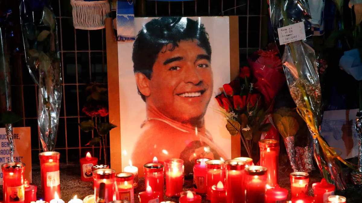Candles and flowers are seen outside the San Paolo stadium commemorating soccer legend Diego Maradona, in Naples, on Nov. 26, 2020. (Alessandra Tarantino/AP Photo)