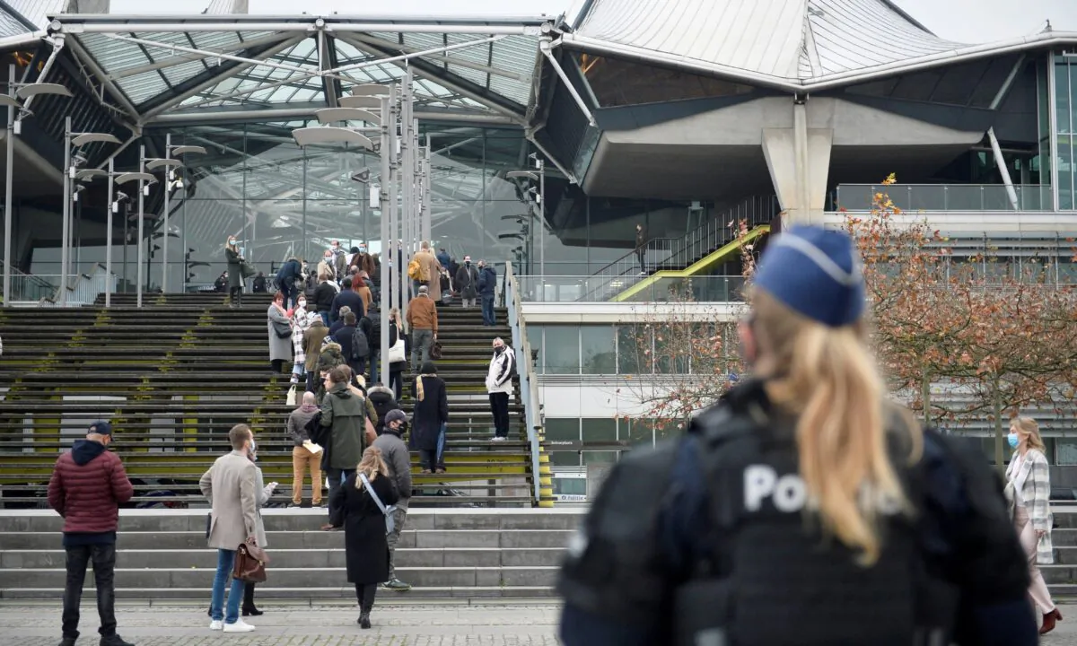 People wait to enter the court building in Antwerp, Belgium, on Nov. 27, 2020. (Johanna Geron/Reuters)