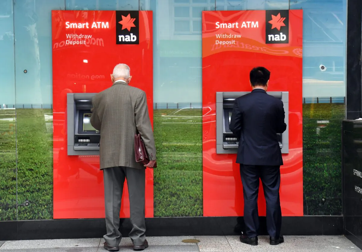 Two people use National Australia Bank (NAB) ATMs in Melbourne on May 2, 2019. (William West/AFP via Getty Images)