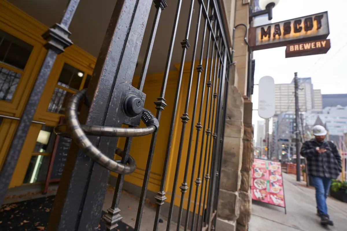 A worker walks past the locked entrance to Mascot Brewery in Toronto, Ontario, on Nov. 23, 2020. (Geoff Robins/AFP via Getty Images)