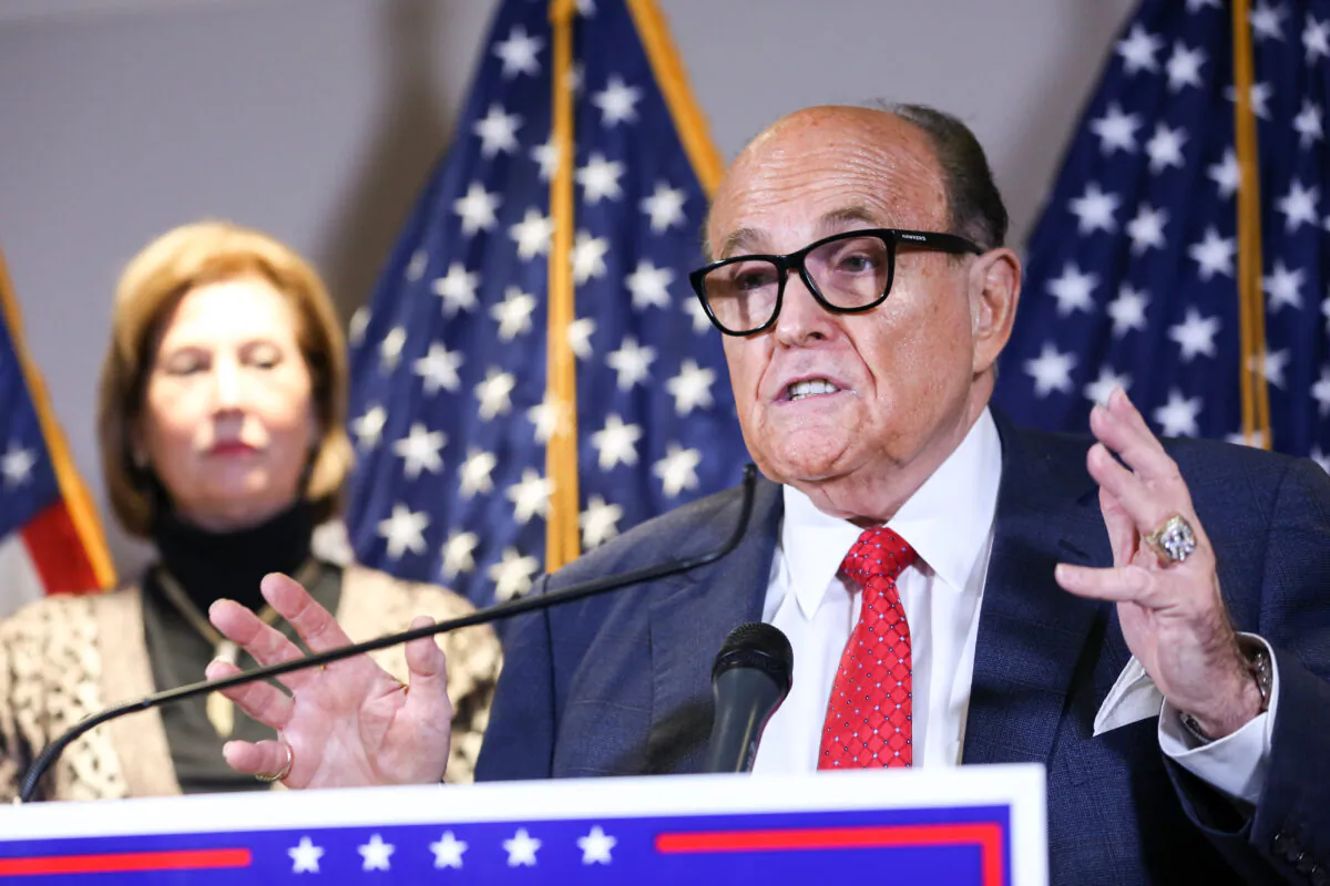 President Donald Trump's lawyer lawyer and former New York City Mayor Rudy Giuliani speaks to media as Trump campaign lawyer Sidney Powell looks on during a press conference at the Republican National Committee headquarters in Washington on Nov. 19, 2020. (Charlotte Cuthbertson/The Epoch Times)