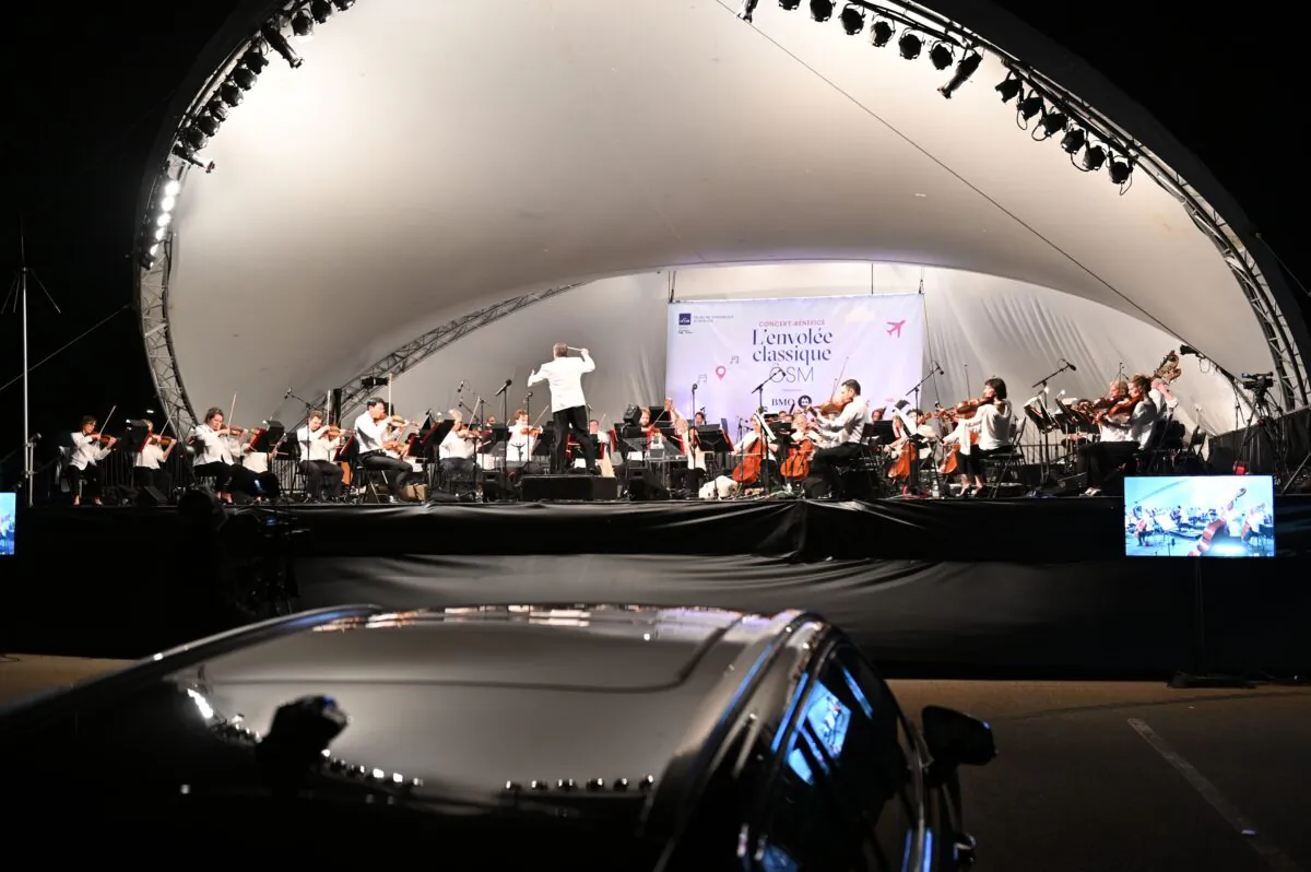 The Montreal Symphony Orchestra performs in a parking lot at the Montreal-Pierre Elliott Trudeau International Airport on Aug. 5, 2020, during a socially-distanced "drive-in" concert amid the COVID-19 outbreak. (Eric Thomas/AFP via Getty Images)