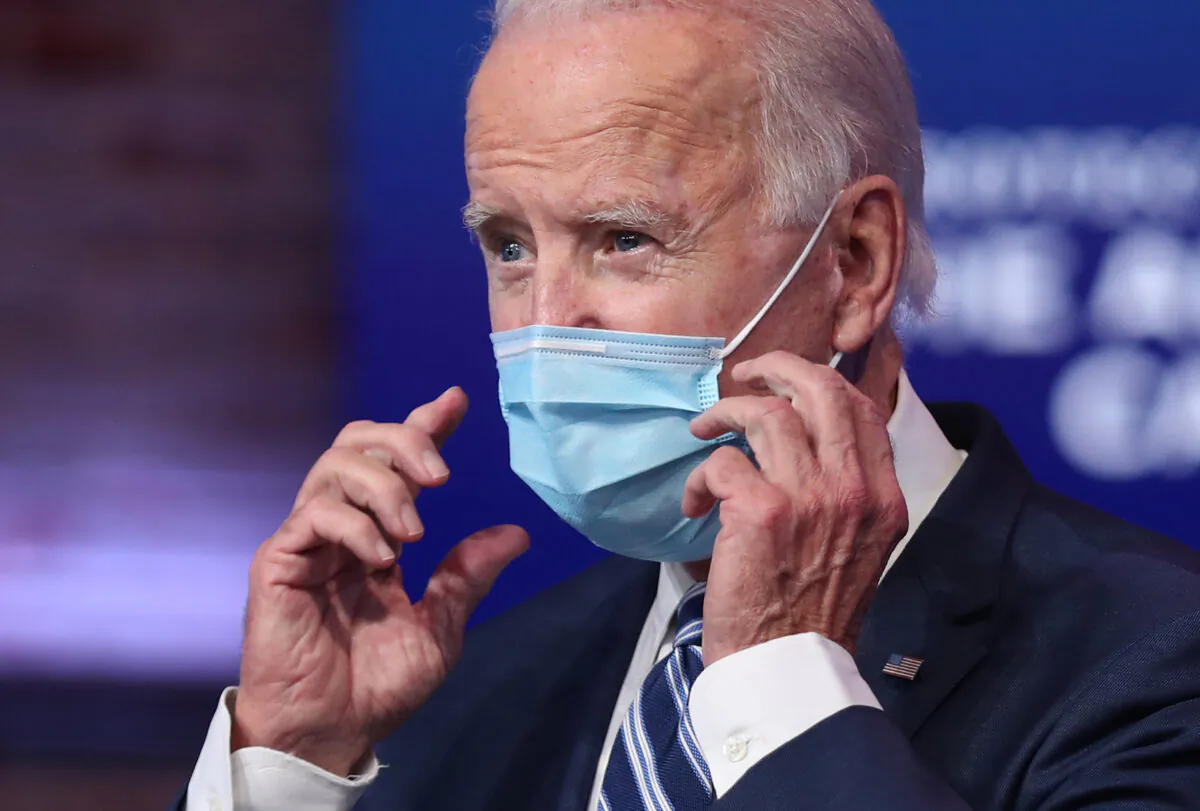 Joe Biden removes his mask to address the media about the Trump Administration’s lawsuit to overturn the Affordable Care Act at the Queen Theater in Wilmington, Del., on Nov. 10, 2020. (Joe Raedle/Getty Images)