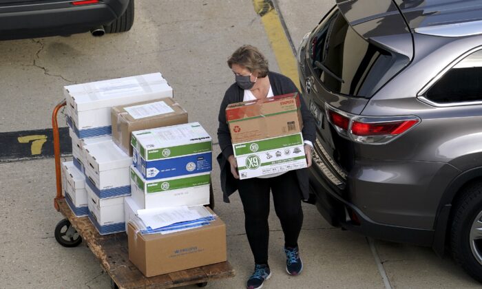 Election officials from around Dane County bring ballots into the Monona Terrace in Madison, Wis., for a recount, on Nov. 19, 2020. (Steve Apps/Wisconsin State Journal via AP)