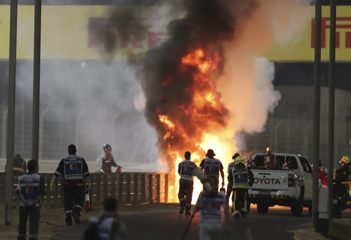 Marshals run to extinguish Haas driver Romain Grosjean's car after an accident during the Formula One Bahrain Grand Prix in Sakhir, Bahrain, on Nov. 29, 2020. (Kamran Jebreili/AP Photo)