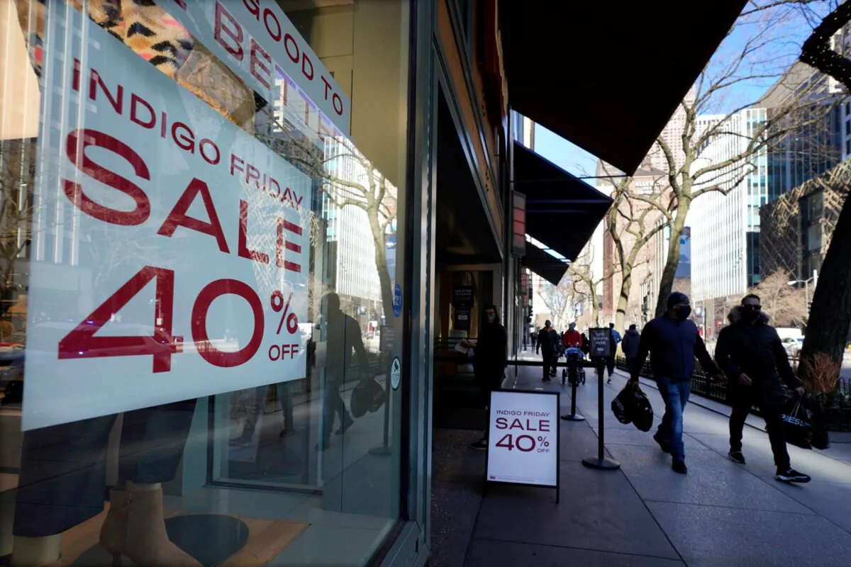 Shoppers pass an Indigo Friday 40% Off sign on Chicago's famed Magnificent Mile shopping district in Chicago, Ill., on Nov. 28, 2020. (Charles Rex Arbogast/AP Photo)