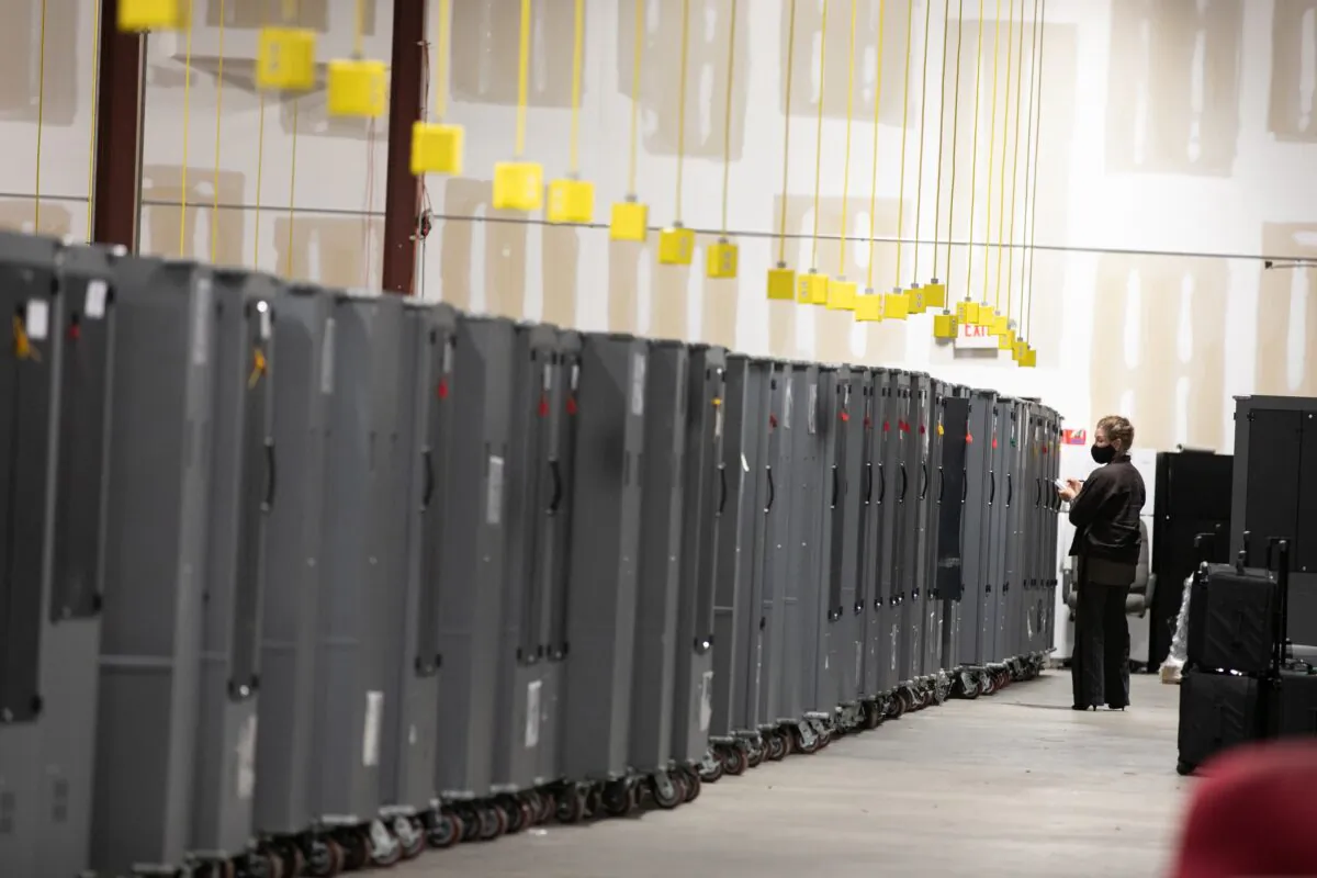A Georgia Republican Party poll watcher looks over voting machine transporters being stored at the Fulton County Election Preparation Center in Atlanta, Ga., on Nov. 4, 2020. (Jessica McGowan/Getty Images)