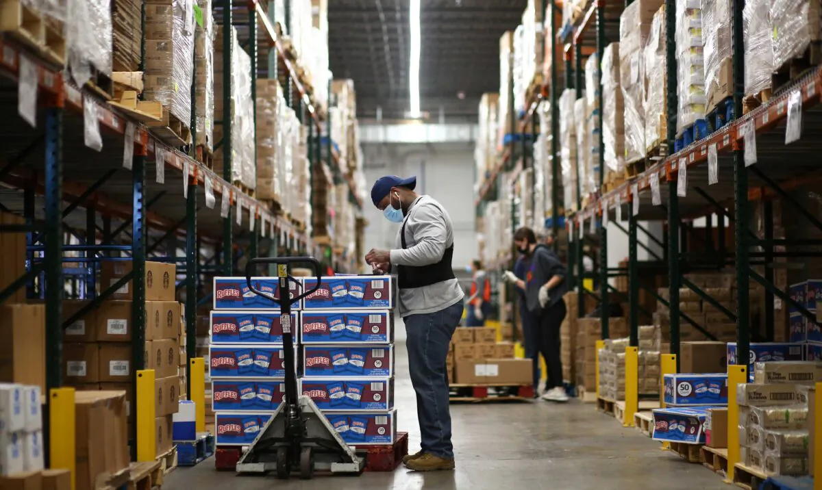 A staff member at Food Bank of the Rockies stocks boxes of food in their warehouse to be distributed to people in need ahead of Thanksgiving in Denver, Colo., on Nov. 25, 2020. (Kevin Mohatt/Reuters)
