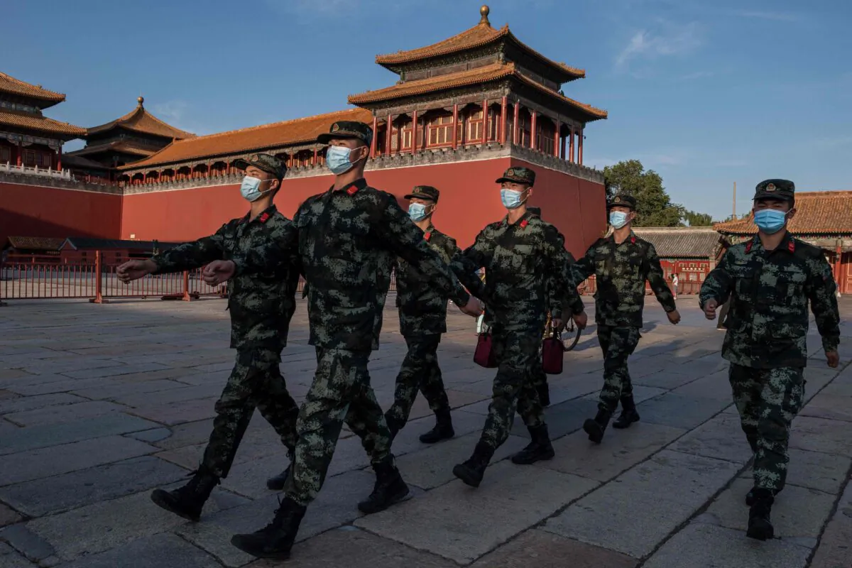 Paramilitary police officers wearing face masks march next to the entrance of the Forbidden City in Beijing, on Sept. 20, 2020. (Nicolas Asfouri/AFP via Getty Images)