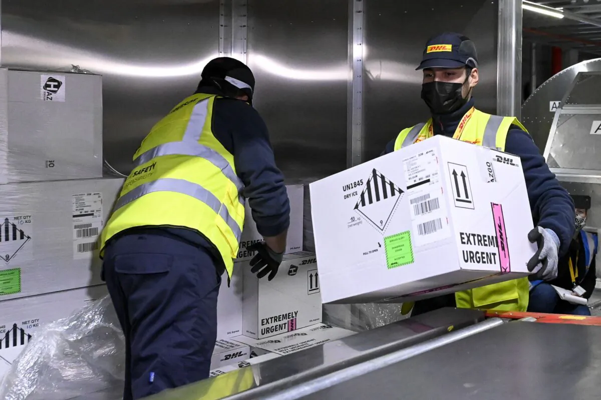 Workers at the DHL Express hub at Brussels Airport in Belgium, where COVID-19 vaccine manufacturer Pfizer is located, on Dec. 1, 2020. The airport has set up a task force to work on the logistics involved in the import and export of COVID-19 vaccines. (Dirk Waem/Belga Mag/AFP via Getty Images)