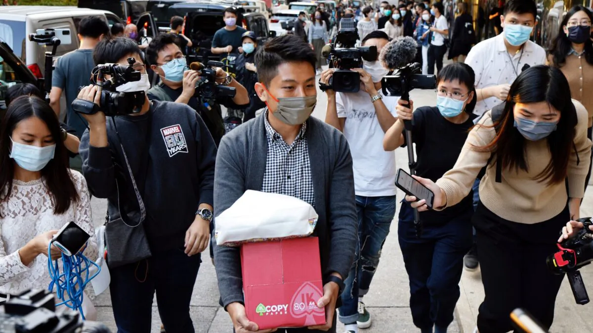 i-Cable TV news journalist leaves with a box after being laid off in Hong Kong on Dec.1, 2020. (Tyrone Siu/Reuters)