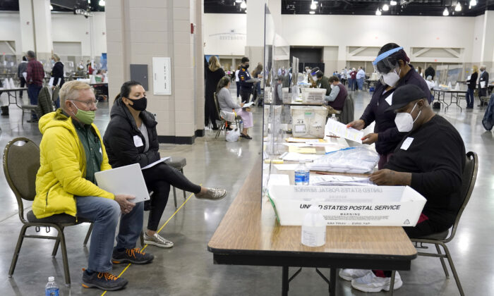 Election workers, right, verify ballots as recount observers, left, watch during a Milwaukee hand recount of presidential votes at the Wisconsin Center in Milwaukee, Wis., on Nov. 20, 2020. (Nam Huh/AP Photo)