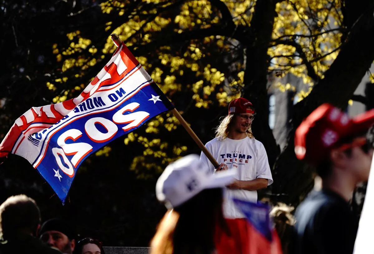A supporter of President Donald Trump waves a Trump flag in Madison, Wis., on Nov. 7, 2020. (Bing Guan/Reuters)