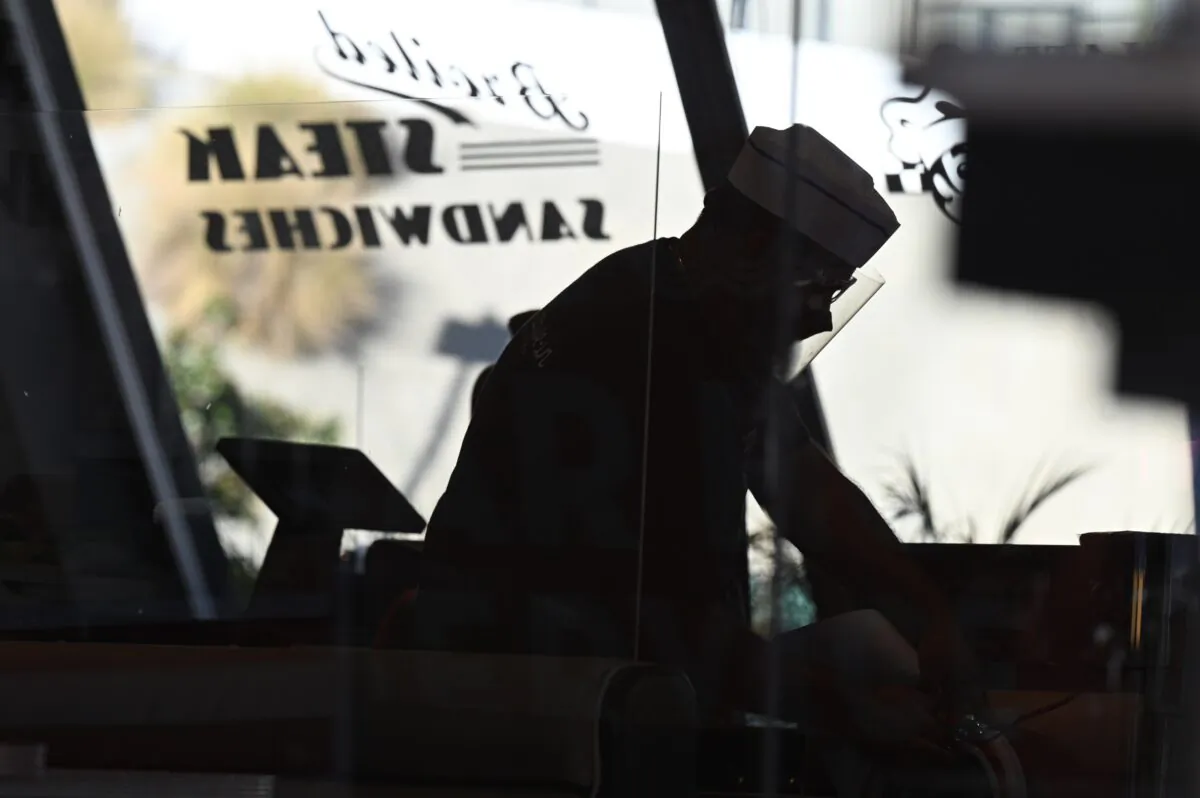 Restaurant servers clean tables inside Mel's drive-in diner after Los Angeles County banned outdoor dining, in West Hollywood, Calif., on Nov. 30, 2020. (Robyn Beck/AFP via Getty Images)