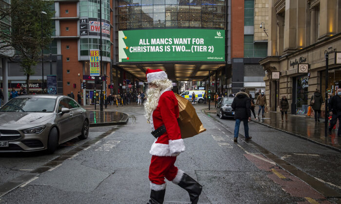 A man dressed as Father Christmas walks past COVID-19 signage in Manchester, England, on Dec. 2, 2020. (Anthony Devlin/Getty Images)