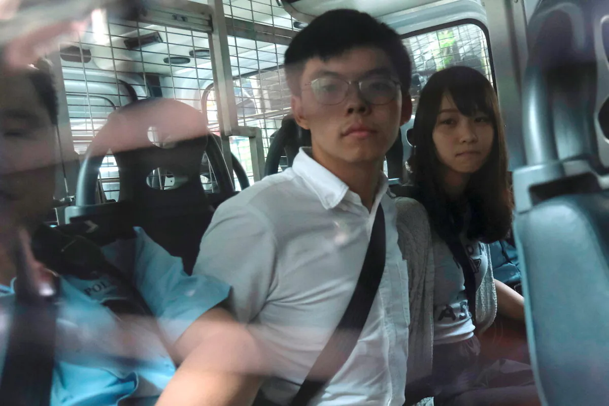 Pro-democracy activists Joshua Wong and Agnes Chow arrive at the Eastern Court by police van after being arrested in Hong Kong, on Aug. 30, 2019.(Tyrone Siu/Reuters)